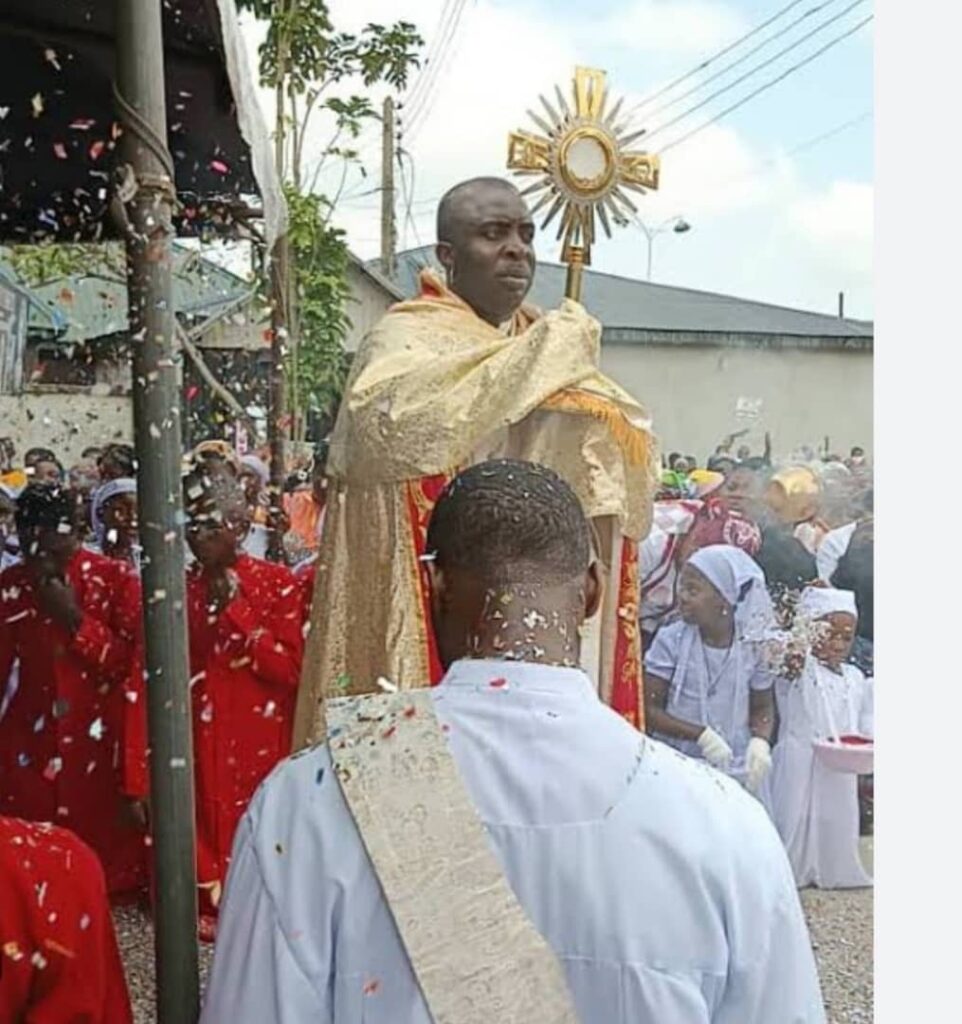 A Nigerian priest blessing people with the Blessed Sacrament