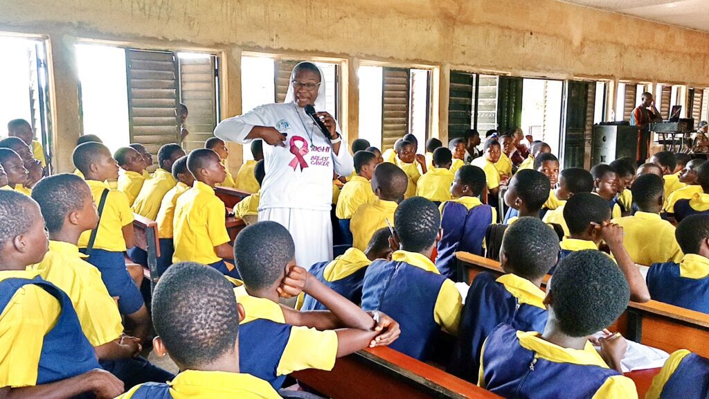 Sr. Grace, a health educator, demonstrating breast self-exam steps to students during a school awareness program. Breast cancer awareness in Nigerian schools.